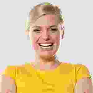 Smiling woman wearing a yellow shirt against a plain background. Smiling woman wearing a yellow shirt against a plain background.