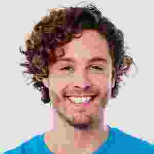 Smiling young man with curly hair against a plain background. Smiling young man with curly hair against a plain background.
