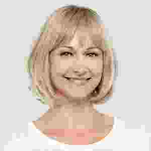 Smiling woman with short blonde hair and bangs wearing a white top. Smiling woman with short blonde hair and bangs wearing a white top.
