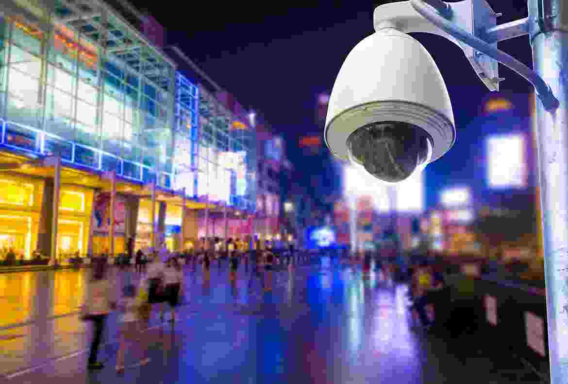 A security camera overlooking a vibrant city street at night.