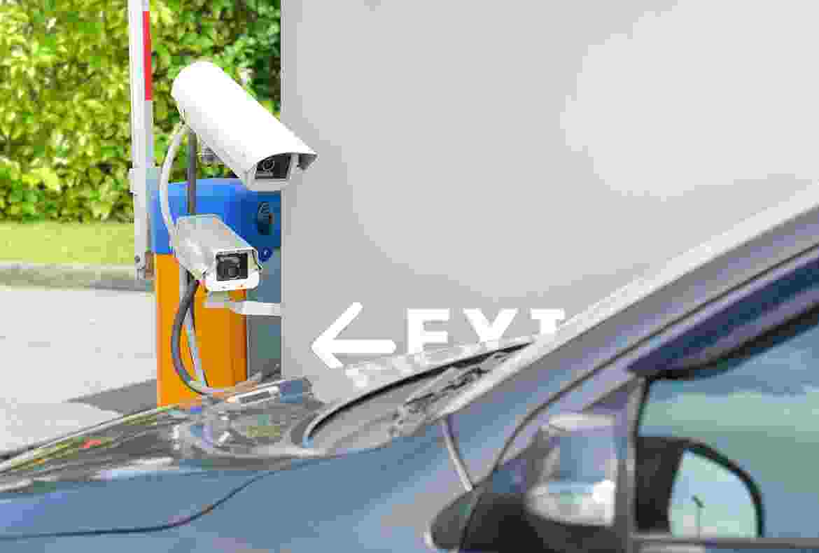A car parked near a security camera with a 'EXIT' arrow on the ground.