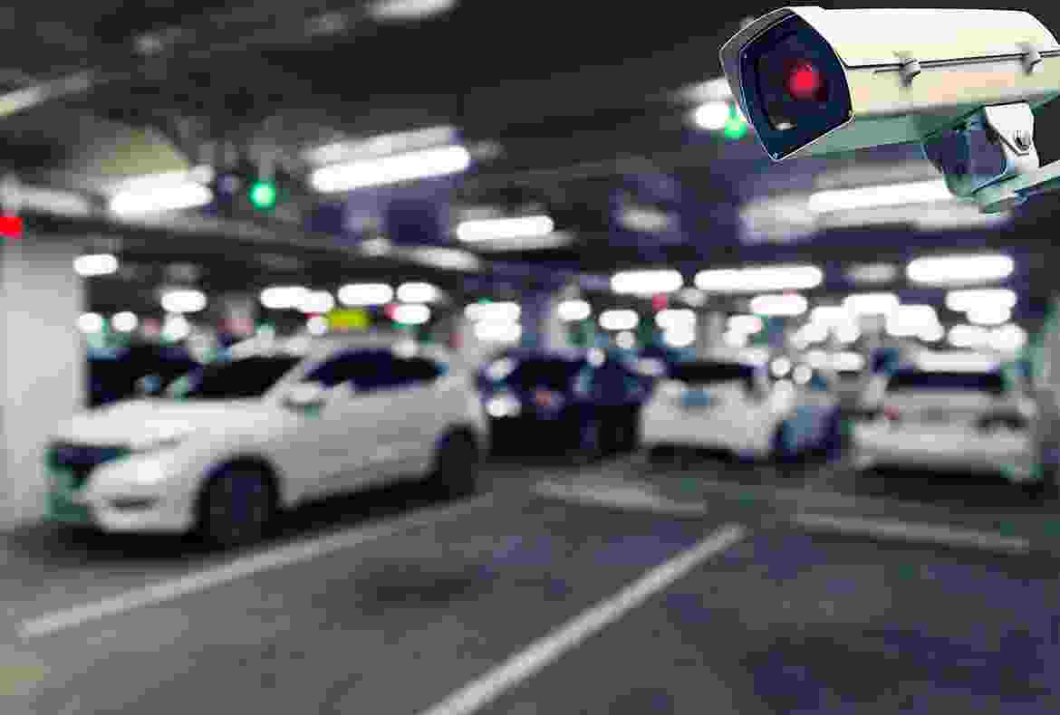 Blurred image of cars parked in an indoor parking garage with a traffic signal.