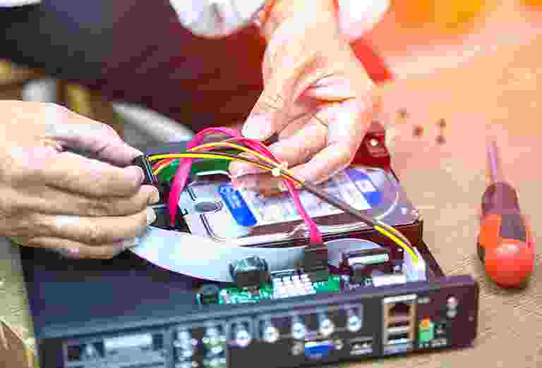 Hands connecting colorful wires to electronic equipment. Hands connecting colorful wires to electronic equipment.