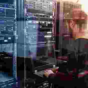 Person managing servers in a data center with digital overlays. Person managing servers in a data center with digital overlays.