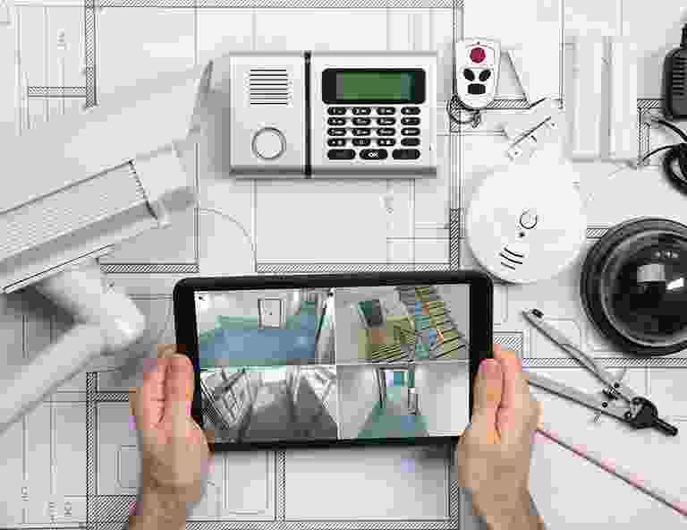 Person monitoring surveillance cameras on a tablet indoors. Person monitoring surveillance cameras on a tablet indoors.