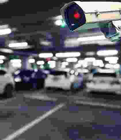 A blurry image of a busy parking garage with cars and a traffic light. A blurry image of a busy parking garage with cars and a traffic light.