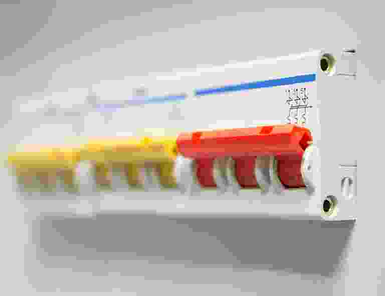 Close-up of a circuit breaker panel with red and yellow switches. Close-up of a circuit breaker panel with red and yellow switches.