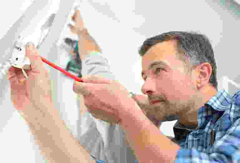 Man measuring wall with tape measure. Man measuring wall with tape measure.