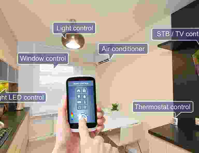 Person controlling smart home devices via a smartphone app. Person controlling smart home devices via a smartphone app.
