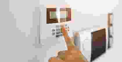Hand pressing buttons on a modern thermostat control panel. Hand pressing buttons on a modern thermostat control panel.