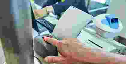 Person using calculator and writing on a notebook at a desk. Person using calculator and writing on a notebook at a desk.