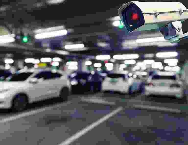 Blurry image of cars parked in an indoor parking garage with overhead lights and a traffic signal. Blurry image of cars parked in an indoor parking garage with overhead lights and a traffic signal.