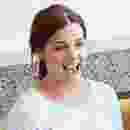 A young woman with earrings smiling brightly indoors. A young woman with earrings smiling brightly indoors.