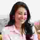 Smiling woman with long dark hair in a pink shirt. Smiling woman with long dark hair in a pink shirt.