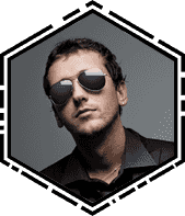 Man wearing sunglasses and a dark jacket looking confident.