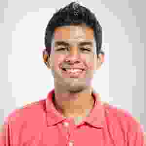 Young man smiling, wearing a coral polo shirt. Young man smiling, wearing a coral polo shirt.