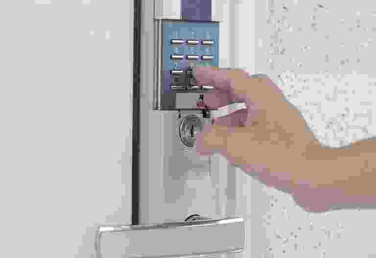 Hand inserting a key into a door lock. Hand inserting a key into a door lock.