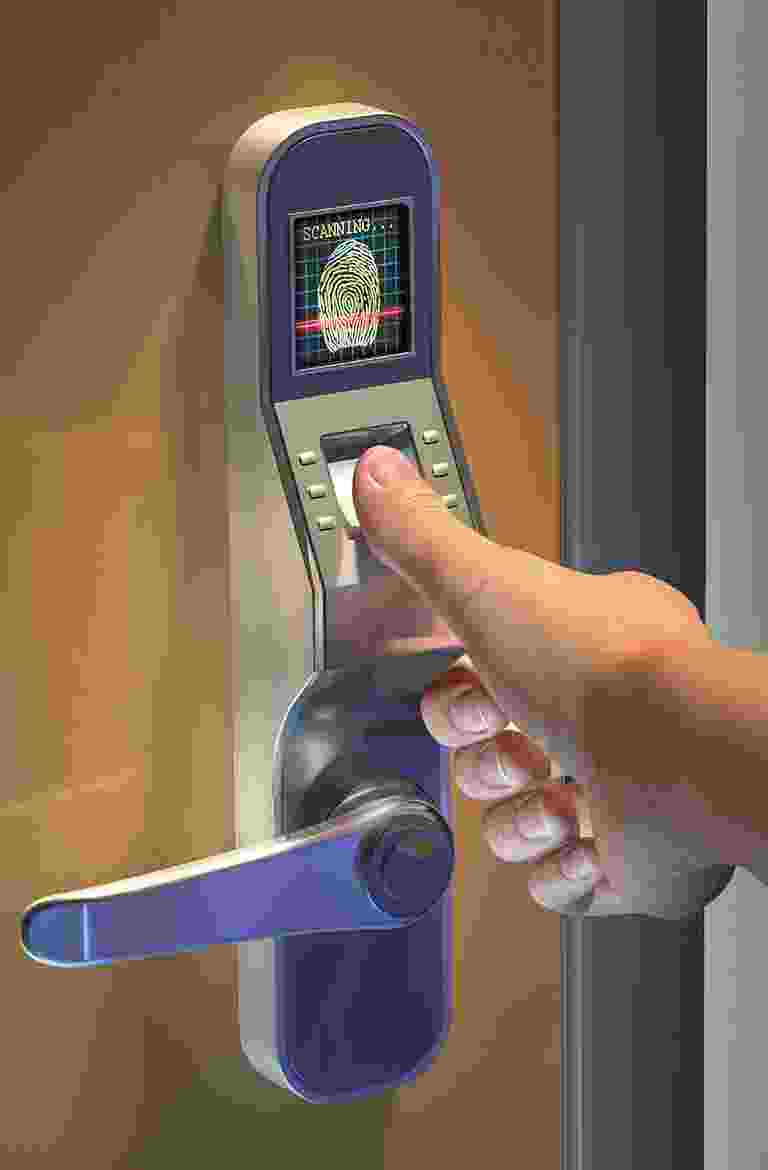 A hand holding a card to unlock a smart door lock. A hand holding a card to unlock a smart door lock.