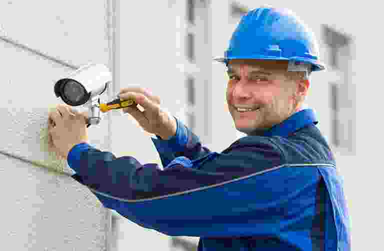 Electrician installing a device on an electrical panel. Electrician installing a device on an electrical panel.