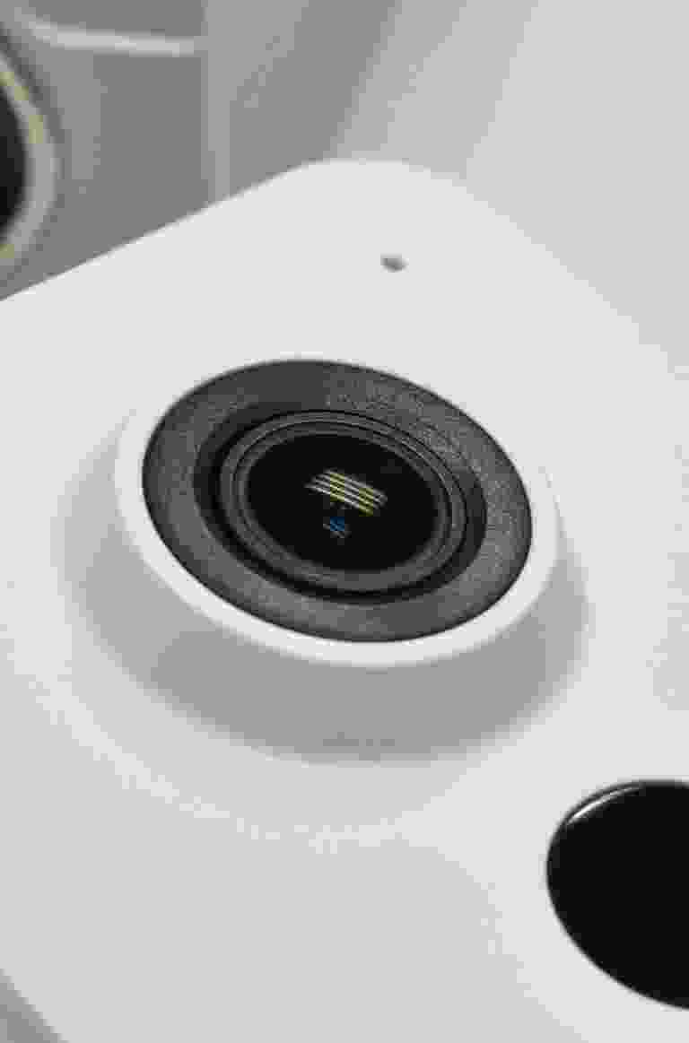 Close-up of a smartphone camera lens on a white device. Close-up of a smartphone camera lens on a white device.