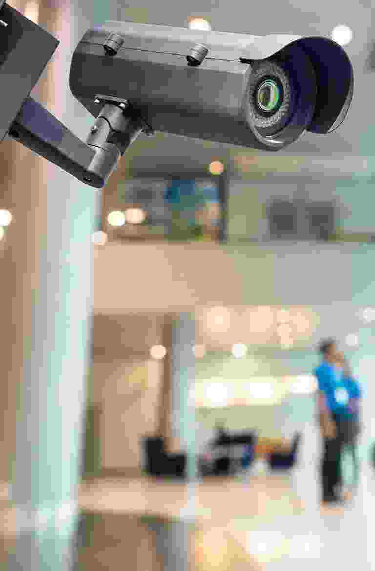 A telescope indoors with a person in the background. A telescope indoors with a person in the background.