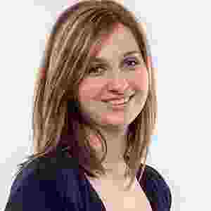 Portrait of a smiling woman with light brown hair and a dark top. Portrait of a smiling woman with light brown hair and a dark top.